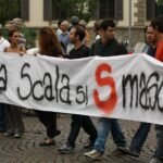 Protesters carry a hand-painted banner through a Milan street during an Italian general strike