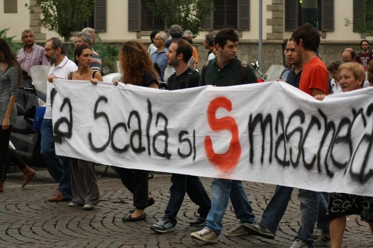 Protesters carry a hand-painted banner through a Milan street during an Italian general strike