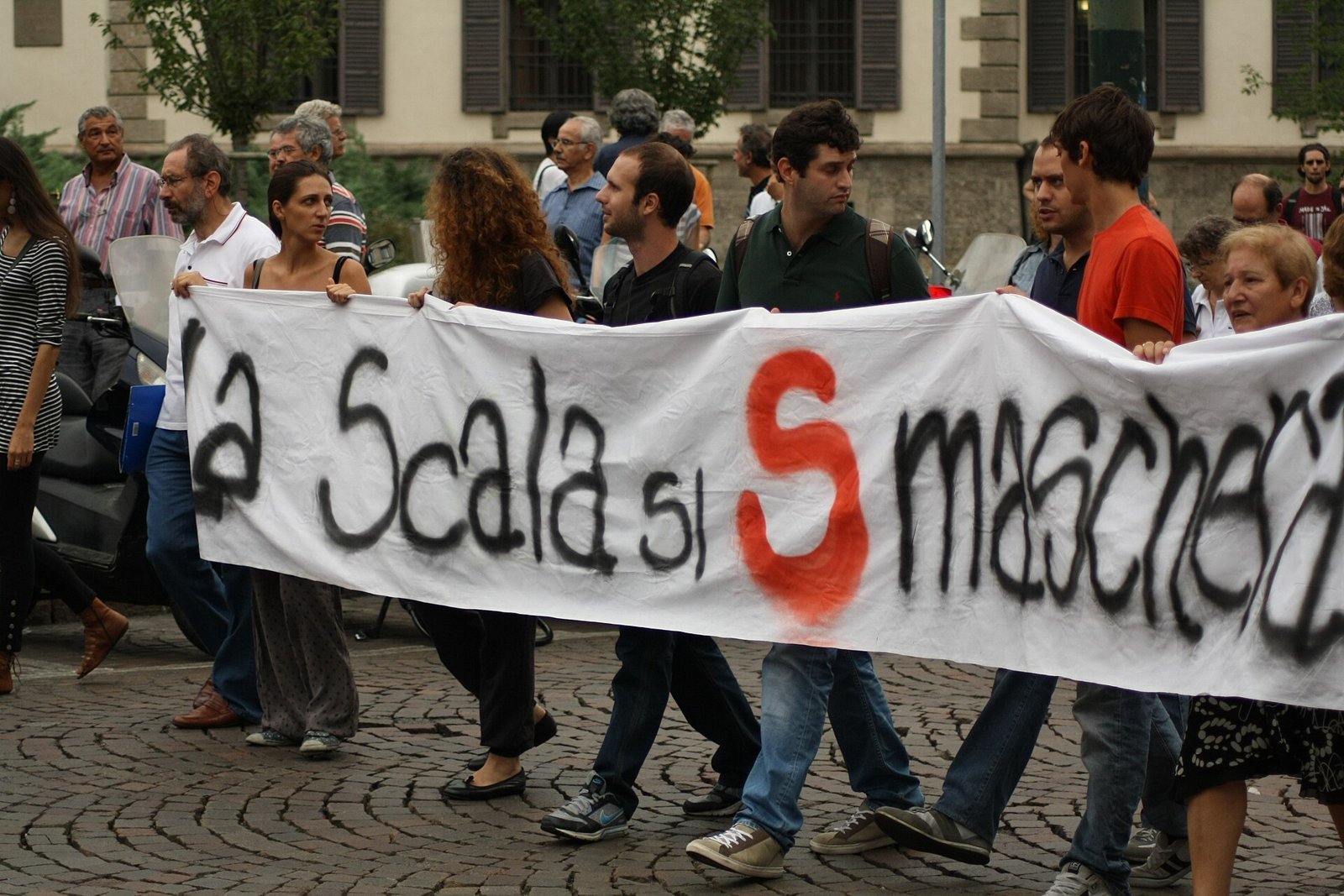 Protesters carry a hand-painted banner through a Milan street during an Italian general strike